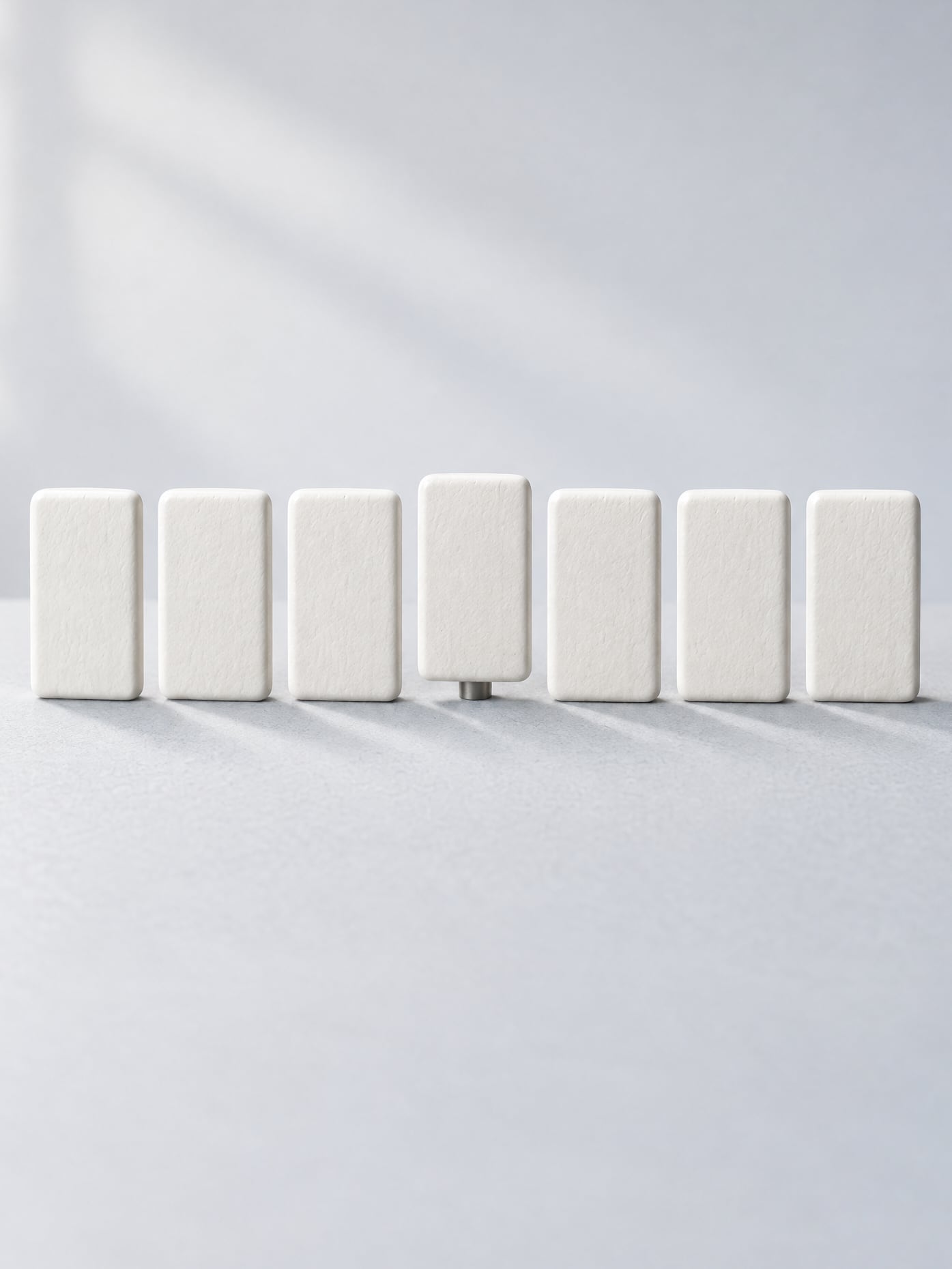 A row of teeth where only one stands on a screw, and it is hard to tell which one.